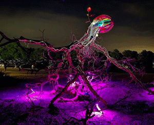 public art at TIP upsidedown tree with bright pink light