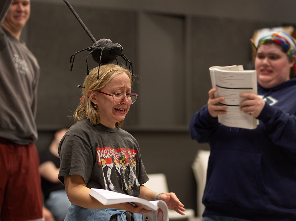 Actor with a toy spider puppet on their head