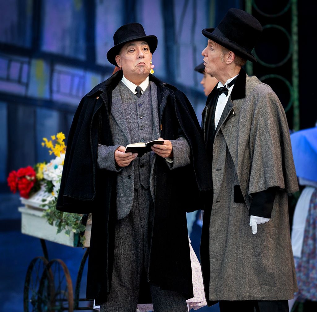 Henry higgins and Colonel Pickering chatting in front of a flower cart