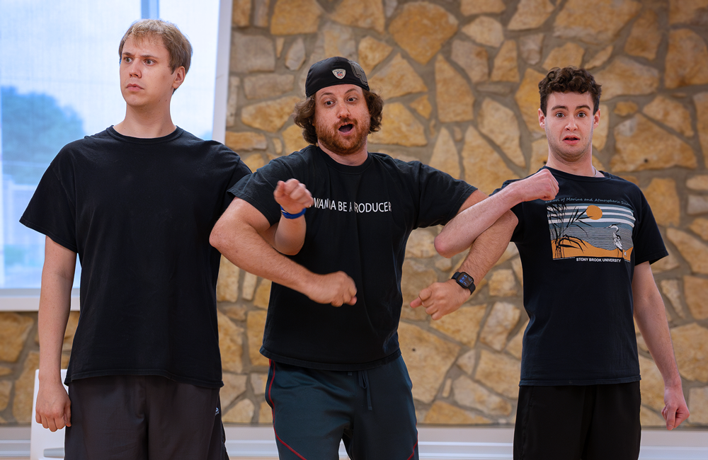 Actors dancing with arms linked