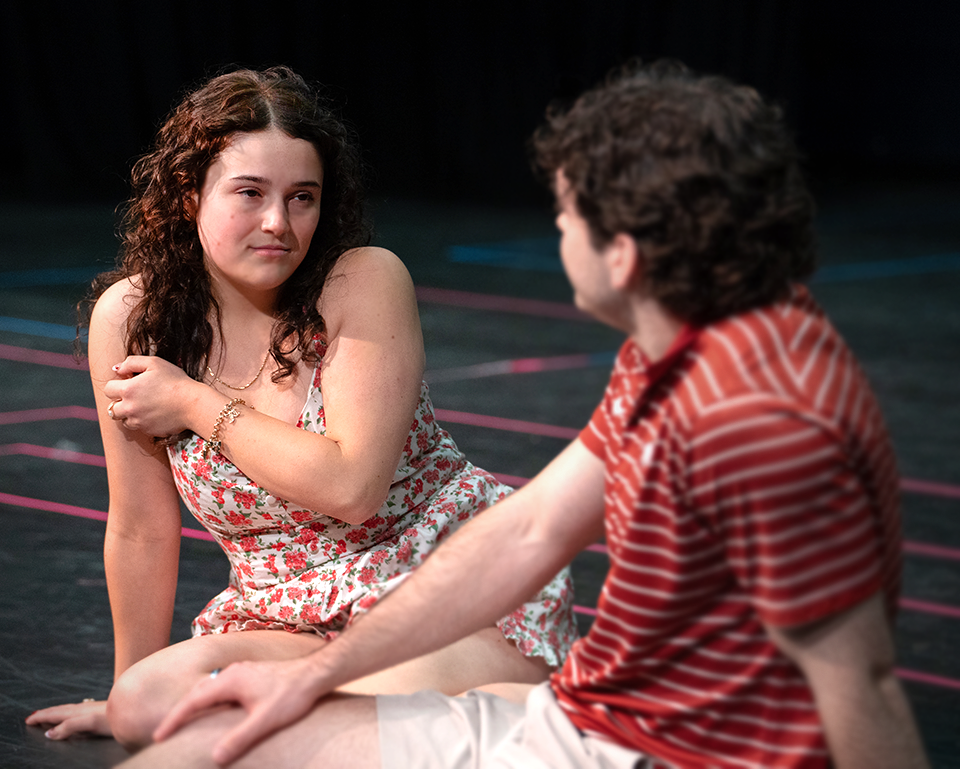 Actor and actress sitting on floor talking