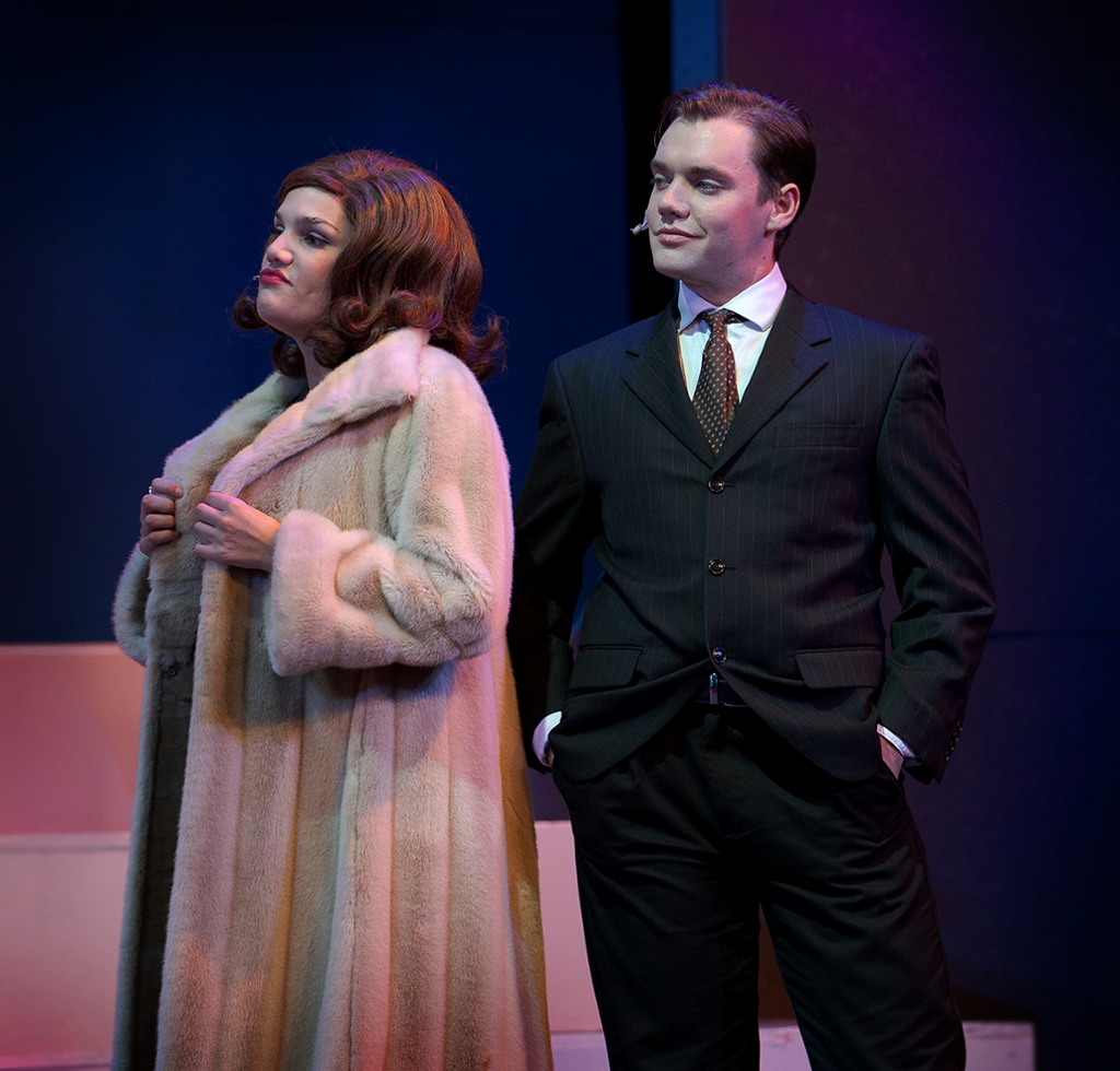 woman in a fur coat and man in the backgroung in a suit