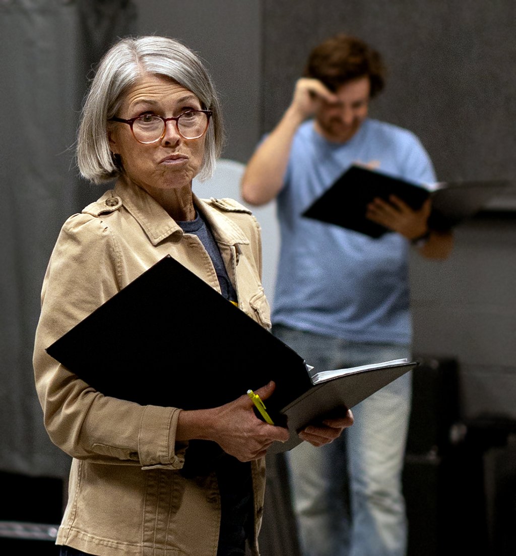 Actress holding a script and practicing a scene during rehearsal