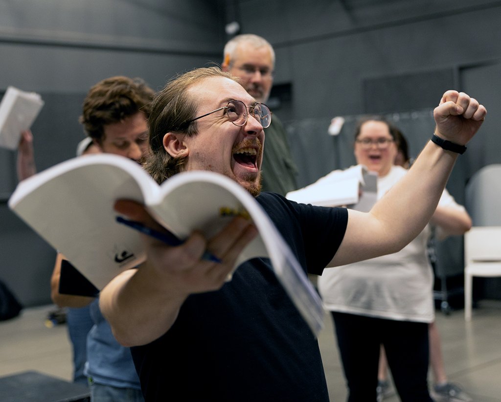 actor laughing with script in hand