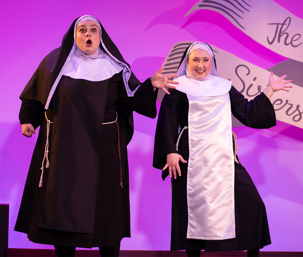 two nuns dancing and singing on stage